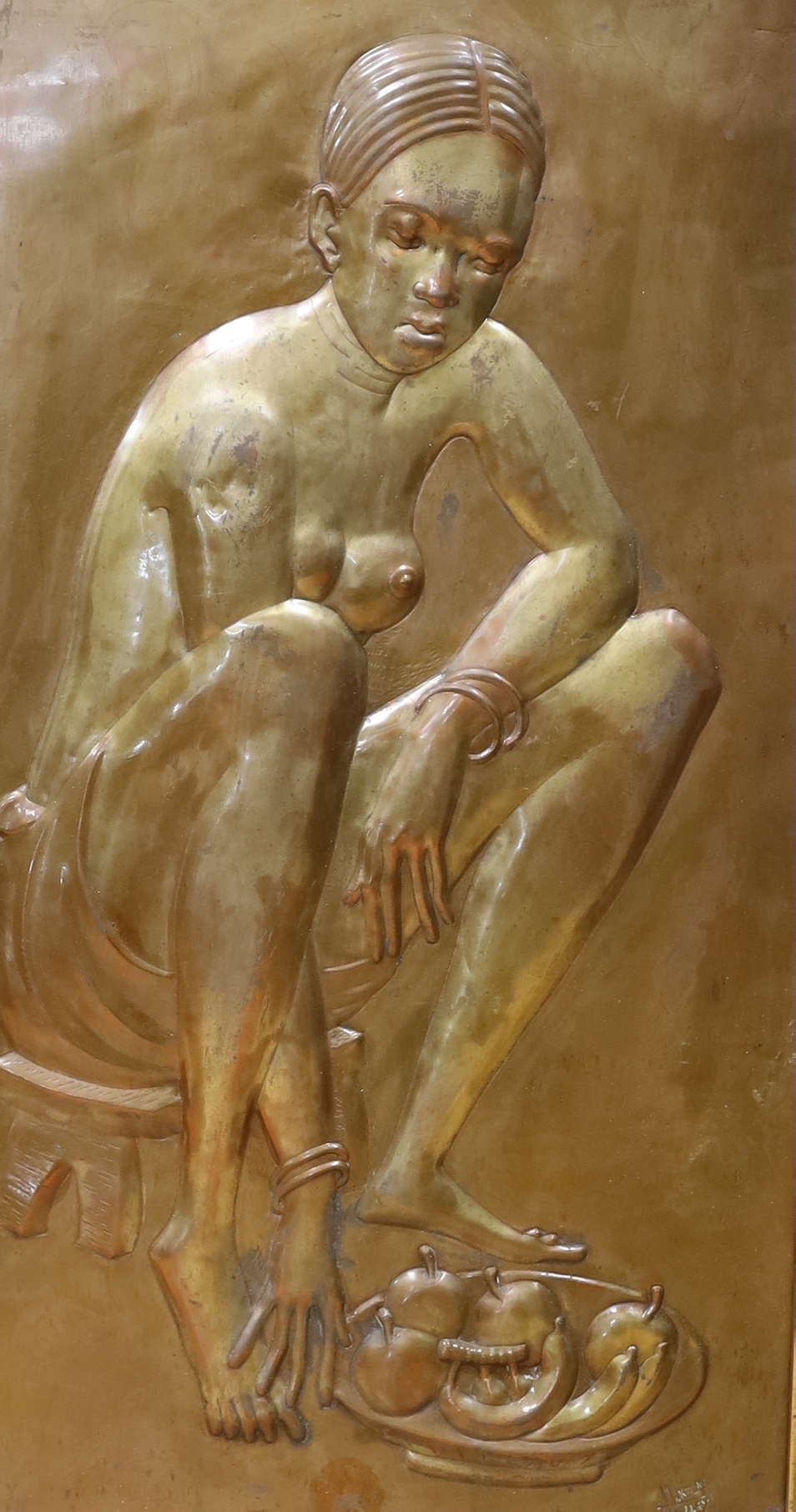 An embossed copper panel depicting a seated African lady